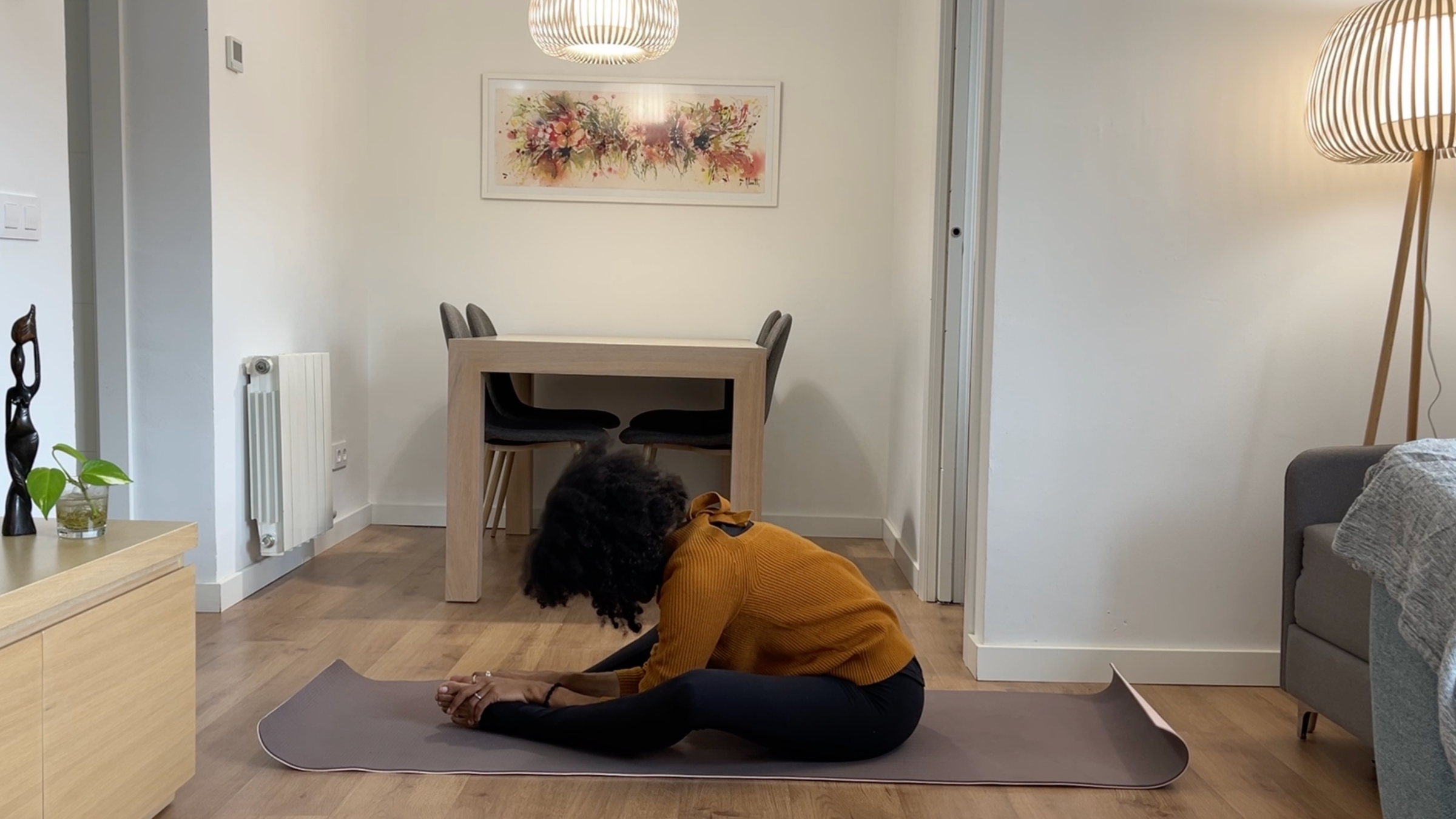 Laia Bové seated in Bound Angle Pose with the soles of her feet together while softly folding forward.